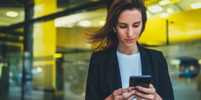Frau mit Handy auf der Strasse
