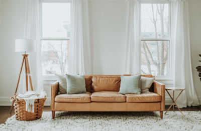 Sofa with laundry basket and stylish lamp in a cozy living room