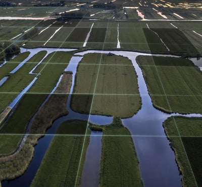 Angled high view of countryside Netherlands overlaid with a glowing digital grid pattern