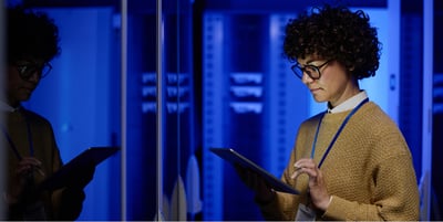 Woman with laptop in server room