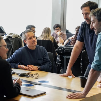 Team meeting comparing ServiceNow and Dynamics 365 business solutions on a conference table.