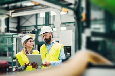 woman and man looking at tablet in factory environment