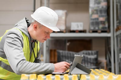 Man wearing hard hat looking at tablet
