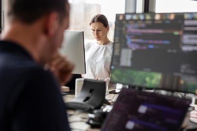 Woman coding behind a computer screen