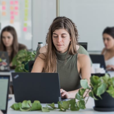 Businesswoman using a laptop in an office, symbolizing the analysis of B2B customer journeys with Adobe CJA.